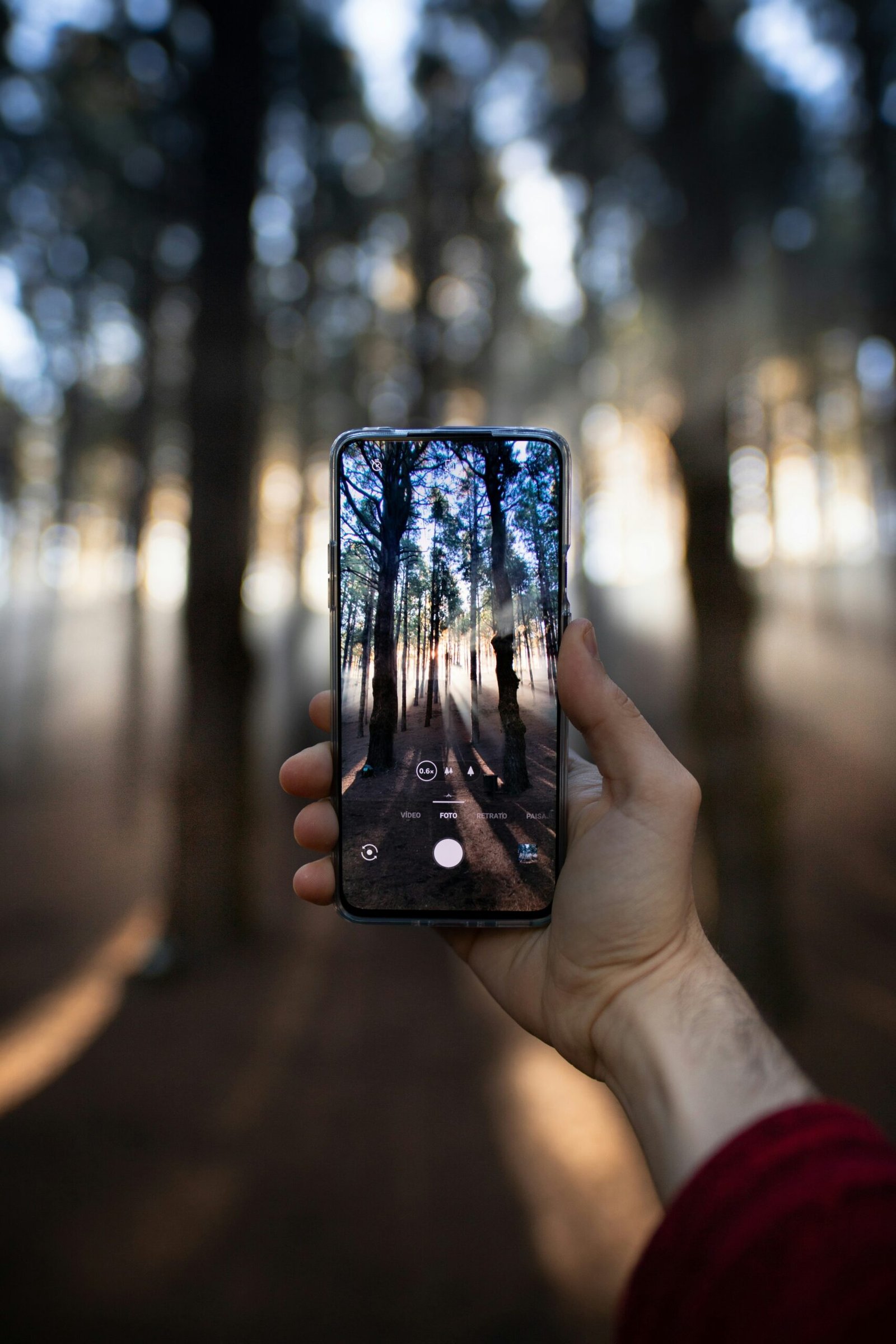 person holding black smartphone taking photo of city lights during night time